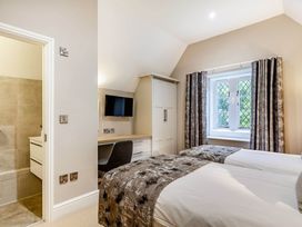 A bedroom with twin beds and a desk at The Gatehouse in Praze-An-Beeble