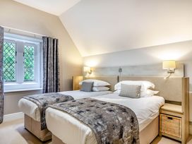A bedroom with twin beds and a window at The Gatehouse in Praze-An-Beeble