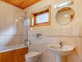 A bathroom with a bathtub, toilet, and sink at Woodland Lodge Spa, Praze-An-Beeble