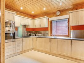A kitchen with cabinets and appliances at Woodland Lodge Spa in Praze-An-Beeble