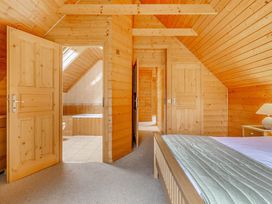 A bedroom with wood paneling and doors at Woodland Lodge Spa, Praze-An-Beeble