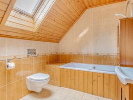 A bathroom with a toilet, bathtub, and sink at Woodland Lodge Spa in Praze-An-Beeble