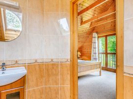 A bathroom with a sink and door leading to a bedroom at Woodland Lodge Spa in Praze-An-Beeble