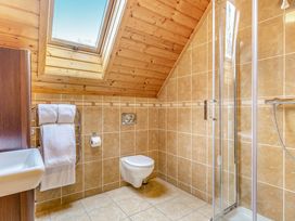 A bathroom featuring a shower, toilet, and sink at Woodland Lodge Spa in Praze-An-Beeble