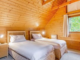 A bedroom with two beds and a window at Woodland Lodge Spa in Praze-An-Beeble