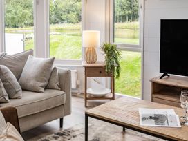 A living room with a sofa and lamp at Lake View Spa in Praze-An-Beeble