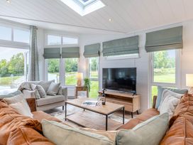 A living room with a sofa and a television at Lake View Spa in Praze-An-Beeble
