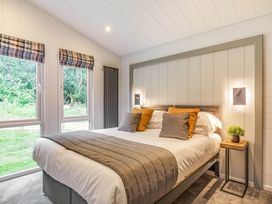 A bedroom with a bed and windows at Lake View Spa in Praze-An-Beeble
