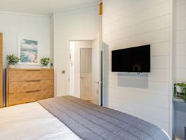 A bedroom with a bed and a television mounted on the wall at Lake View Spa in Praze-An-Beeble