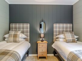 A bedroom with two beds and a nightstand at Argel Spa in Praze-An-Beeble