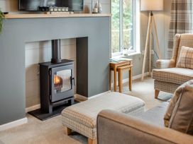 A living room with a fireplace and television at Argel in Praze-An-Beeble