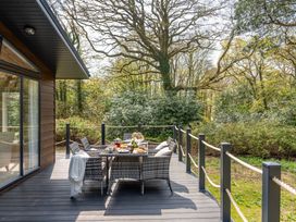 An outdoor deck with a table and chairs at Argel in Praze-An-Beeble