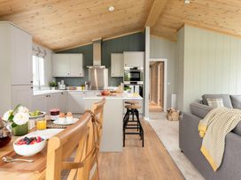 A kitchen with a dining table and bar stools at Argel Spa Pet in Praze-An-Beeble