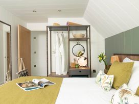 A bedroom with a bed and shelf containing decorative items at Kilden Pet in Praze-An-Beeble