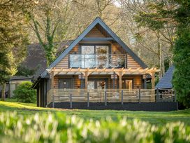 A house with a deck and windows at Lowarth Lodge Spa Pet Praze-An-Beeble