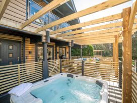 An outdoor area with a hot tub and dining set at Lowarth Lodge Spa Pet Praze-An-Beeble