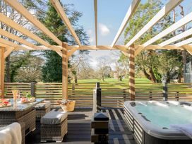 A garden with outdoor seating and a hot tub at Lowarth Lodge Spa Pet Praze-An-Beeble