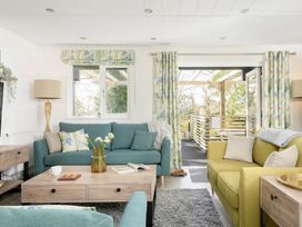 A living room with a green sofa and coffee table at Lowarth Lodge Spa Pet in Praze-An-Beeble
