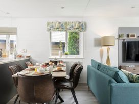 A kitchen with a dining table and chairs at Lowarth Lodge Spa Pet in Praze-An-Beeble