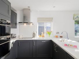 A kitchen with appliances and a window at Lowarth Lodge Spa Pet Praze-An-Beeble