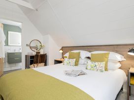 A bedroom with a bed and bedside table at Lowarth Lodge Spa Pet, Praze-An-Beeble