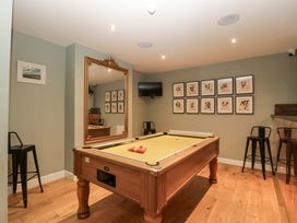 A game room with a pool table and bar stools at The Swan 