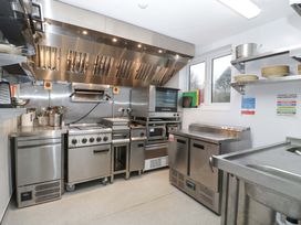 A commercial kitchen with stainless steel appliances and counter space at The Swan 