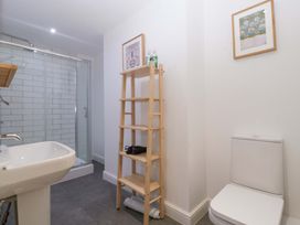 A bathroom with a shower, sink, toilet and shelf at The Swan in Whitney-On-Wye