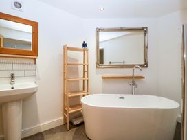 A bathroom with a bathtub, sink, mirror and shelf at The Swan in Whitney-On-Wye