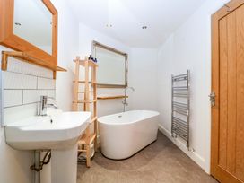 A bathroom with a bathtub, sink, and mirror at The Swan in Whitney-On-Wye