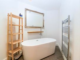 A bathroom with a bathtub and shelves at The Swan in Whitney-On-Wye