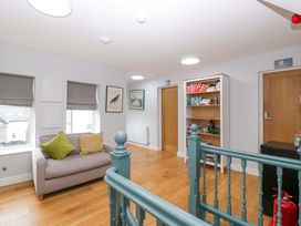 A living room with a sofa and bookshelf at The Swan in Whitney-On-Wye