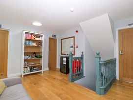 A hallway with a bookshelf and staircase at The Swan in Whitney-On-Wye
