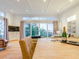 A living room with a dining table and champagne at Milk Wood 2 in Laugharne