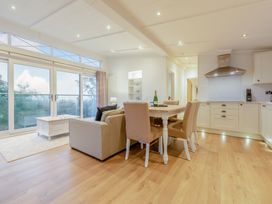 A living room with a dining area and kitchen unit at Milk Wood 2 in Laugharne
