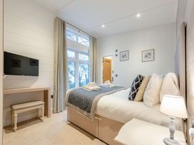 A bedroom with a bed and television at Milk Wood 2, Laugharne