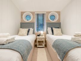 A bedroom with twin beds and a window at Milk Wood 2 in Laugharne