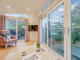 A living room with a chair and a table at Milk Wood 2 in Laugharne