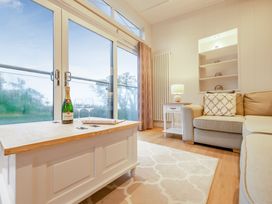 A living room with a coffee table and champagne on display at Milk Wood 2 in Laugharne