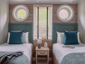 A bedroom with two beds and a window at Milk Wood 2 Spa in Laugharne