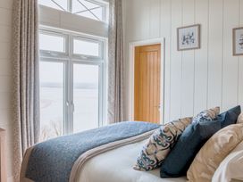 A bedroom with a bed and window at Milk Wood 2 Spa in Laugharne