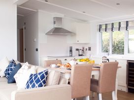 A kitchen with a dining area featuring a table and chairs at Milk Wood 2 Spa Laugharne