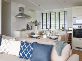 A kitchen with dining table and appliances at Milk Wood 2 Spa in Laugharne