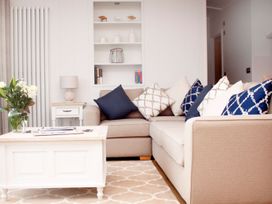 A living room with a sofa, coffee table, and lamp at Milk Wood 2 Spa in Laugharne