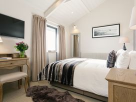 A bedroom with a bed and desk at Dylan Spa in Laugharne