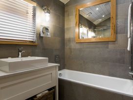 A bathroom with a sink and tub at Dylan Spa in Laugharne