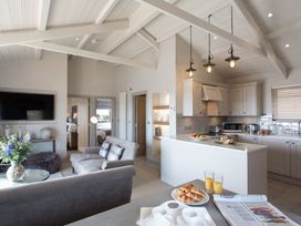 A living room with kitchen area and breakfast items at Dylan Spa in Laugharne