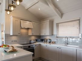 A kitchen with cabinets, sink, stove, and fruits at Dylan Spa in Laugharne