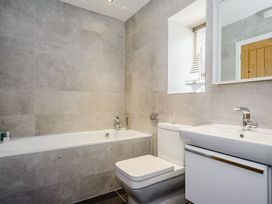A bathroom with a bath tub, toilet, and sink at The View in Laugharne