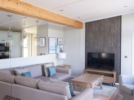 A living room with a sofa and television at Milk Wood 3 in Laugharne